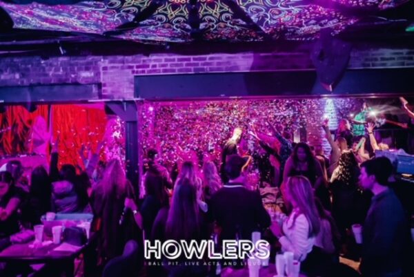 drag queens on stage in howlers newcastle with a room full of party goes dancing and enjoying the show.